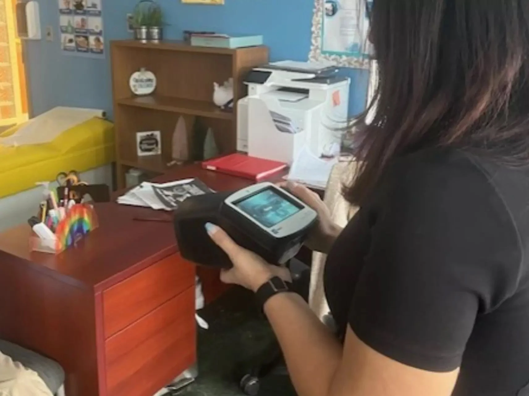 Leiry Sargenti looks at the screen of a Spot vision screener in an office